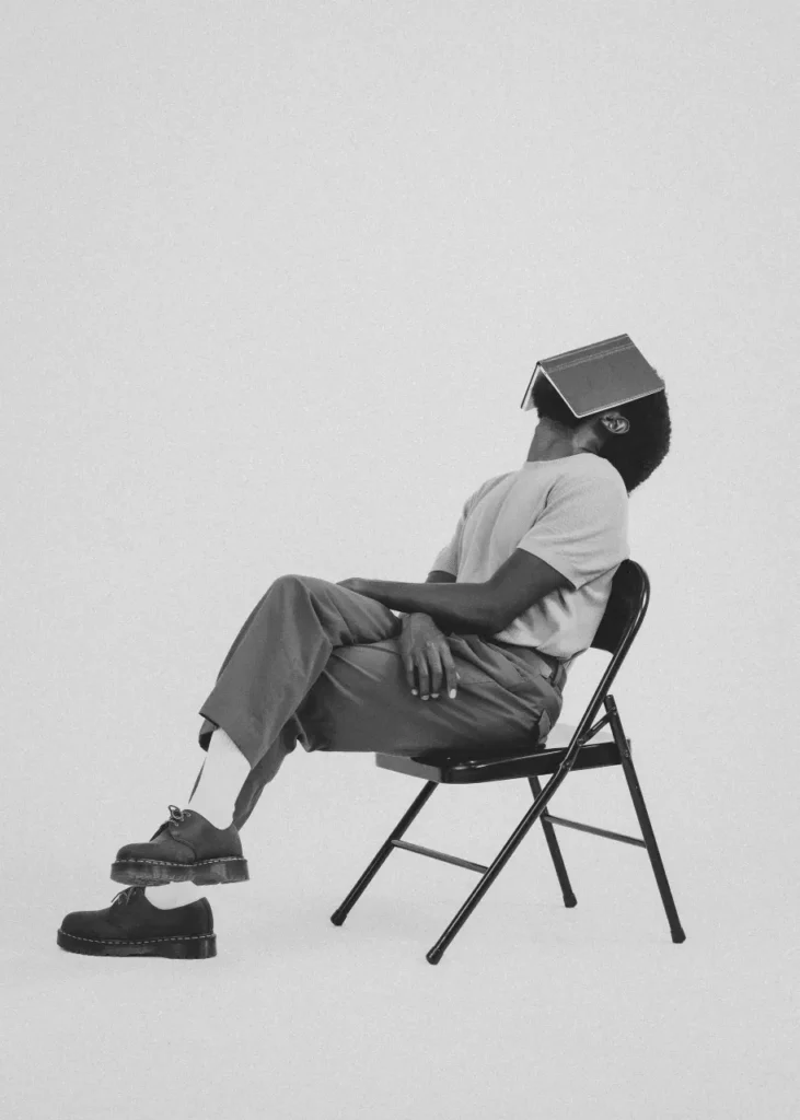 Mike Bosco black and white portrait sitting back with journal on face