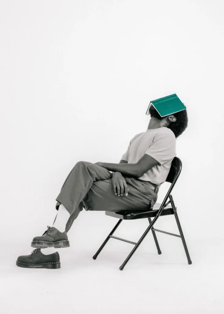 Mike Bosco black and white portrait sitting back with green journal on face